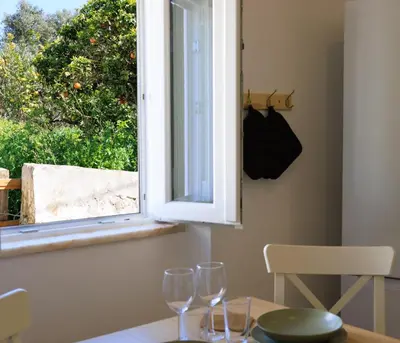 two wine glasses sitting on a table in front of a window at Casinha da Raposeira in Raposeira