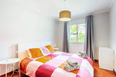 a bedroom with a colorful bed and a window at JMF Apartment in Funchal