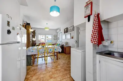 a white kitchen with white cabinets and a sink at Casa Dos Netos in Burgau