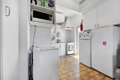 a white bedroom with a bed and a mirror at Casa Dos Netos in Burgau