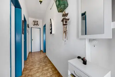 a hallway with white cabinets and blue accents at Casa Dos Netos in Burgau