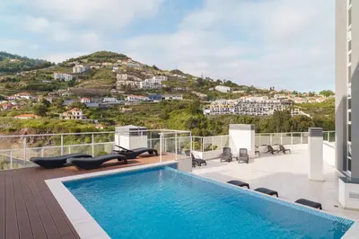 a pool on the roof of a house with a mountain at GuestReady - Duplex paradise in Caniço in Caniço