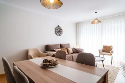 a living room with a table and a couch at GuestReady - Duplex paradise in Caniço in Caniço