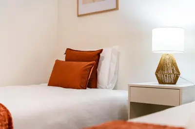 a bedroom with a bed with a nightstand and a lamp at GuestReady - Duplex paradise in Caniço in Caniço