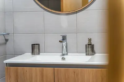 a sink in a bathroom with a mirror at GuestReady - Duplex paradise in Caniço in Caniço