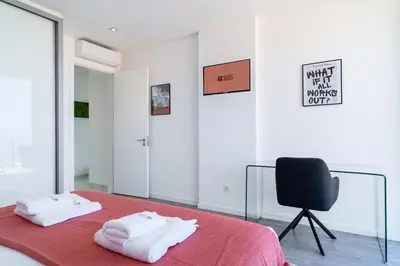 a bedroom with a red bed and a black chair at GuestReady - Sunset Heaven Villa in Calheta