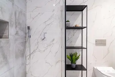 a bathroom with white marble walls and a shower at GuestReady - Sunset Heaven Villa in Calheta
