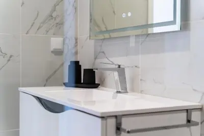 a white bathroom with a sink and a mirror at GuestReady - Sunset Heaven Villa in Calheta