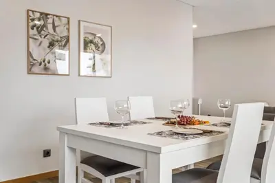 a white dining room with a white table and chairs at Casa das Raposinhas IV, Funchal in Funchal