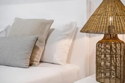 a lamp on a table next to a bed with pillows at Casa das Raposinhas IV, Funchal in Funchal