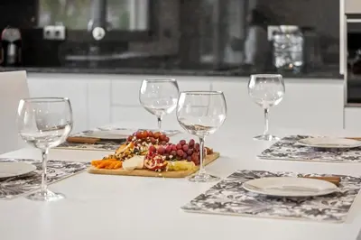 a table with wine glasses and a plate of food at Casa das Raposinhas IV, Funchal in Funchal