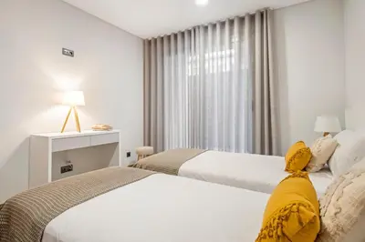 a hotel room with two beds and a window at Casa das Raposinhas IV, Funchal in Funchal