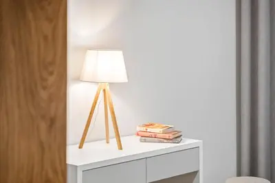 a lamp on a white dresser with books at Casa das Raposinhas IV, Funchal in Funchal