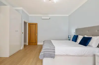 a bedroom with a large white bed with blue pillows at Ocean SkyLine in Arco da Calheta