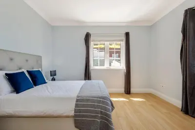 a bedroom with a bed with blue pillows and a window at Ocean SkyLine in Arco da Calheta