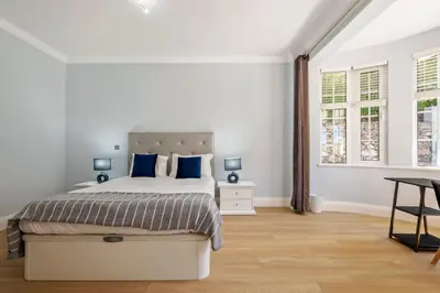 a white bedroom with a bed with blue pillows at Ocean SkyLine in Arco da Calheta