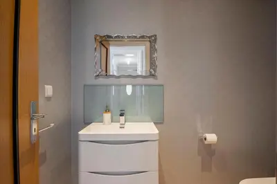 a bathroom with a white sink and a mirror at Ocean SkyLine in Arco da Calheta