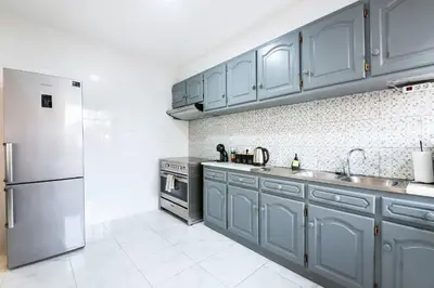 a kitchen with blue cabinets and a stainless steel refrigerator at R&V Paradise by GALMI in Santa Cruz