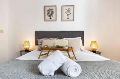 a bedroom with a bed with towels and two lamps at R&V Paradise by GALMI in Santa Cruz