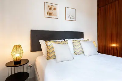 a bedroom with a white bed with a lamp on a table at R&V Paradise by GALMI in Santa Cruz