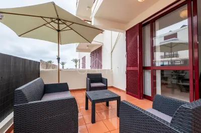 a patio with two chairs and an umbrella at R&V Paradise by GALMI in Santa Cruz