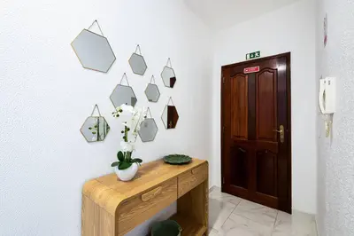 a room with a table with a vase of flowers on a wall at R&V Paradise by GALMI in Santa Cruz