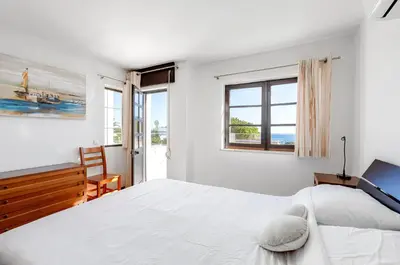 a white bedroom with a large bed and a window at Luz Home - Three Bedroom Villa in Luz