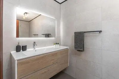 a bathroom with a sink and a mirror at Luz Home - Three Bedroom Villa in Luz