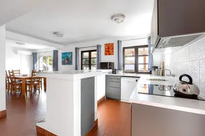 a kitchen with white appliances and a dining room at Luz Home - Three Bedroom Villa in Luz