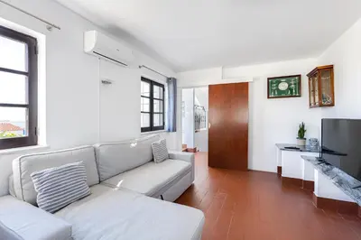 a living room with a couch and a tv at Luz Home - Three Bedroom Villa in Luz