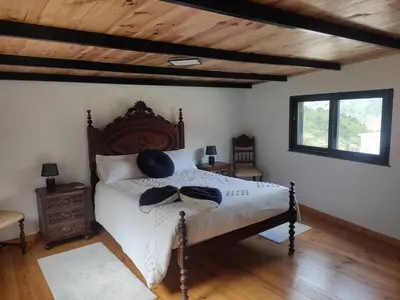 a bedroom with a large bed with a wooden headboard at Little Hideaway in São Vicente