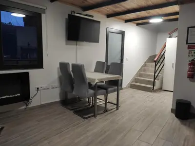 a conference room with a table and chairs and a flat screen tv at Little Hideaway in São Vicente