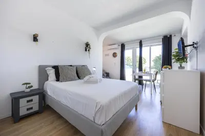 a white bedroom with a bed and a table at Beach Lovers Duplex & Studio by Seewest in Lagos