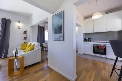 a living room with a white couch and a kitchen at Beach Lovers Duplex & Studio by Seewest in Lagos