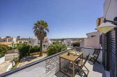 a balcony with a table and chairs and a palm tree at Beach Lovers Duplex & Studio by Seewest in Lagos