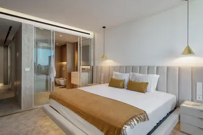 a bedroom with a large bed and a bathroom at Lyra Lux Penthouse by LovelyStay in Funchal
