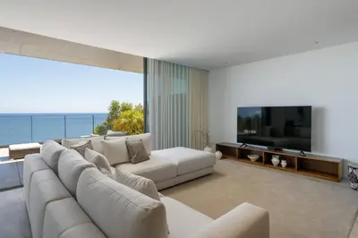 a living room with a large white couch and a television at Lyra Lux Penthouse by LovelyStay in Funchal