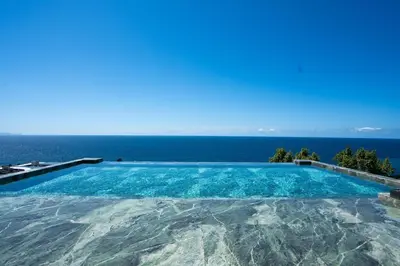 a large swimming pool with a view of the ocean at Lyra Lux Penthouse by LovelyStay in Funchal