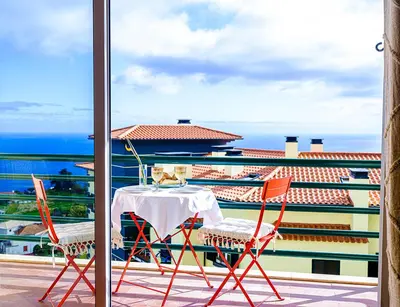 a table and chairs on a balcony with a view of the ocean at Apartment São Martinho - Caniço in Caniço