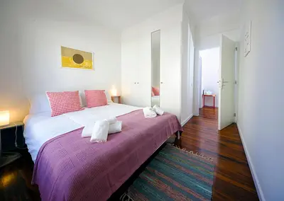 a bedroom with a large bed with a purple blanket at Apartment São Martinho - Caniço in Caniço