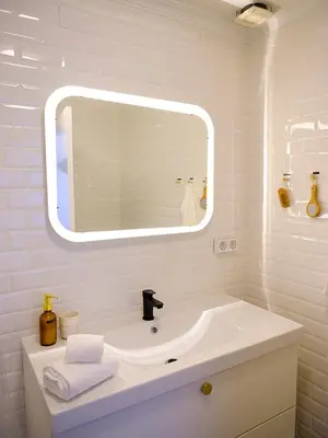 a white bathroom with a sink and a mirror at Apartment São Martinho - Caniço in Caniço