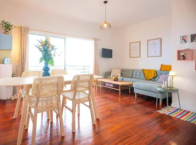 a living room with a table and a couch at Apartment São Martinho - Caniço in Caniço
