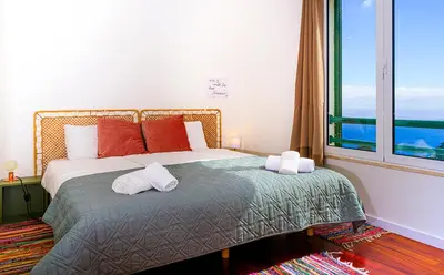 a bedroom with a bed and a large window at Apartment São Martinho - Caniço in Caniço