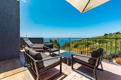 a table with food and drinks on a balcony at Casa Branca-B,beautiful sea view in Estreito da Calheta