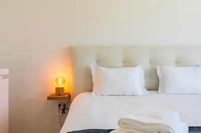 a bedroom with a white bed with towels on it at Casa Branca-B,beautiful sea view in Estreito da Calheta