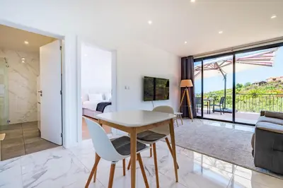 a balcony with a table and chairs and the ocean at Casa Branca-B,beautiful sea view in Estreito da Calheta