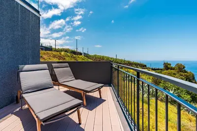 a balcony with two chairs and the ocean at Casa Branca-B,beautiful sea view in Estreito da Calheta