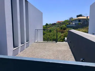 a balcony with a gate on the side of a building at Casa Branca-B,beautiful sea view in Estreito da Calheta