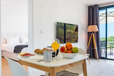 a table with a bowl of fruit and a glass of orange juice at Casa Branca-B,beautiful sea view in Estreito da Calheta