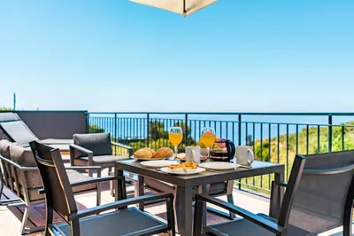 a balcony with a chair and a view of the ocean at Casa Branca-B,beautiful sea view in Estreito da Calheta
